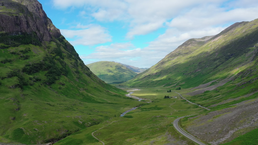 Aerial view of picturesque landscape of Glen Coe, scenic valley in Highlands of Scotland, lush green hills - panorama of Scotland from above, United Kingdom, Great Britain, Europe Royalty-Free Stock Footage #1036122308