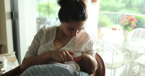 Mother breastfeeding baby while caressing showing affection and love