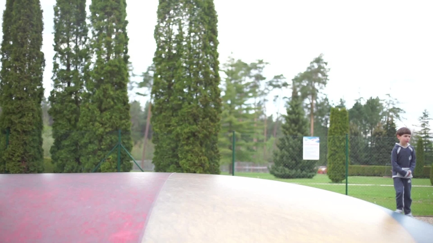 child runs on a big trampoline in the park