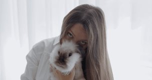 Beautiful caucasian girl holding white bunny. RAW Graded footage 4K slow motion 50fps