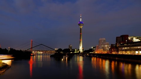 Time-lapse day to night and sunset to night sky of harbor, pier, Rhein tower, promenade on riverside of Rhein River and cityscape at media harbor, in Düsseldorf, Germany,