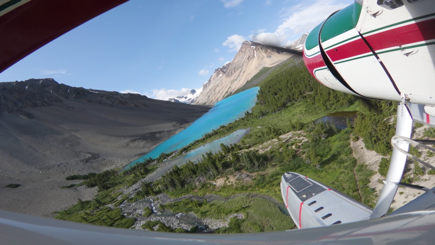 Float Plane Landing On Turquoise Alpine Lake On A Sunny Day