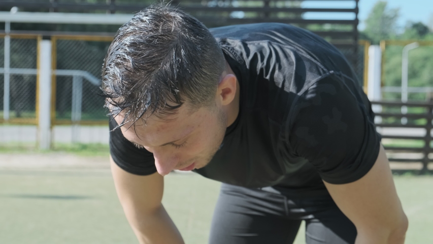 Exhausted man raises head and looks into camera. Close-up tired face and sweaty man finished workout outdoors. Royalty-Free Stock Footage #1036161869