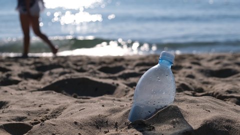 Plastic bottle is on the beach leave by tourist. The problem of pollution of the waters of the oceans with plastic. The concept of abandoning plastic.