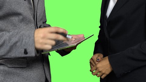 Businessman and businesswoman sign a digital agreement - keyable green screen background