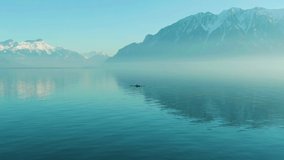 Two Men Kayaking on Clear Day on Turquoise Lake Geneva. Snow-Capped Mountains Reflection. Swiss Alps, Switzerland. Drone is Orbiting - Powered by Shutterstock - Get 15% off with code: PIKWIZARD15