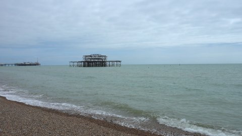 Wide shot of the sea on the south coast of England with Brighton pier in the background.