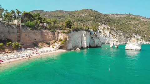 Summer touristic destination in Puglia, Italy: Faraglioni di Puglia Baia delle Zagare - Beach and faraglioni rocks formation (stacks, coastal rocks eroded by waves)