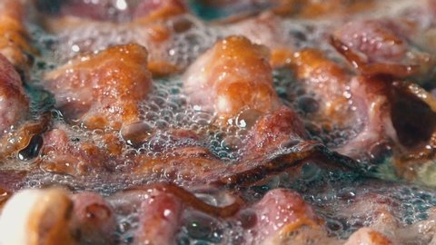 Close Shot of Delicious Crispy Rashers of Bacon Frying in a Pan with Bubbling Hot Oil