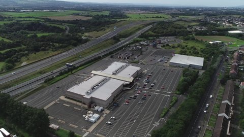 Coatbridge, Glasgow, Scotland; August 24th 2019: Aerial footage over the Showcase Leisure Park at Barrbridge Road at Baillieston. Traffic passing on the M8 motorway. Flying left.