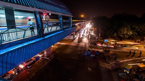 New Delhi, India - March 22, 2017 : Elevated metro station above road intersection in New Delhi downtown time lapse at night tilt