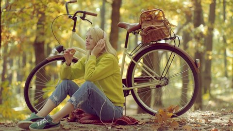 Listen music in headphones Autumn woman. Good morning and nice day. Headphones concept. Holiday outdoor vacation trip