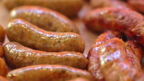 Succulent grilled pork sausages ready for serving at a buffet or catered event in a close up view