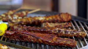 Rotating grill packed with assorted kebabs and grilled meat in a close up view on the food as it passes the camera