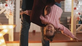 Dad tickling little daughter in slow motion. Happy father having fun with daughter at Christmas porch. Father and daughter in pink pullover at Christmas day. Close-up shot - Powered by Shutterstock - Get 15% off with code: PIKWIZARD15