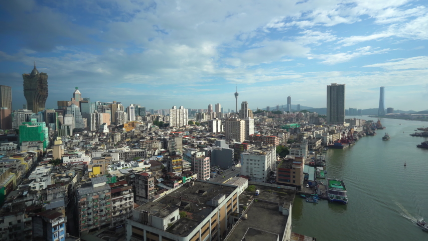 Long shot of thriving city of Macau with densely packed buildings. Pan right.