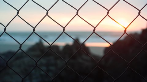 Sunrise through fence. Beautiful sunrise rays slowly appears on top of the lighthouse in VungTau city, the only coastal city in South of Vietnam. VungTau beach is around 100km away from Ho Chi Minh.