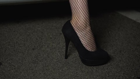 Lady in black fishnet stockings sitting into car, going to nightclub party