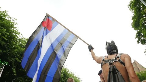STRASBOURG - CIRCA 2015: Man wearing mask and waving Leather Pride flag in slow motion at 14th local edition of the Lesbian Gay Bisexual and Transgender LGBT visibility march, the Gay pride Festi Gays