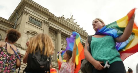 STRASBOURG - CIRCA 2015: Dancing waving gay flag in front of Strasbourg University at the 14th local edition of the Lesbian Gay Bisexual and Transgender LGBT visibility march, the Gay pride Festi Gays