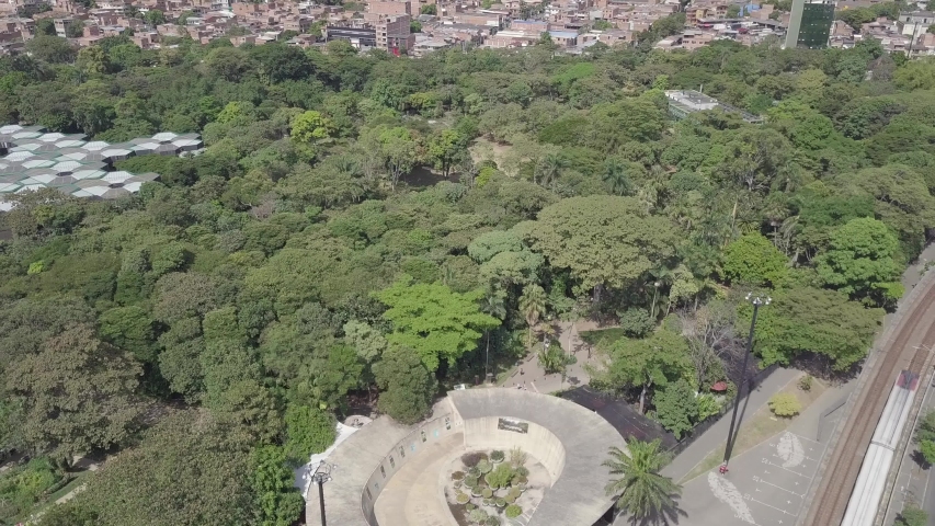 Beautiful slow tilting shot of metro train and Botanical garden; Medellin, Colombia, Parque Explora, Jardin Botanico