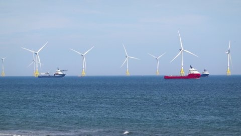 Sea wind farm turbines and ships in Aberdeen, renewable energy. Scotland
