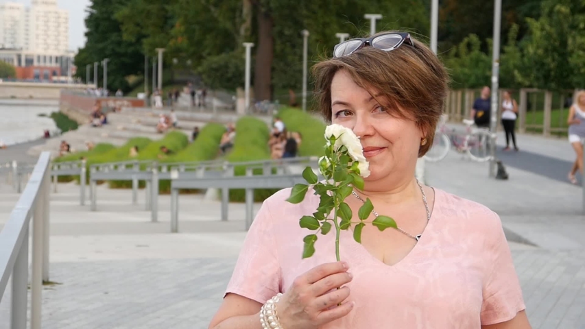Elderly Senior Happy Lady Woman with White Rose Flower in City Park - Portrait