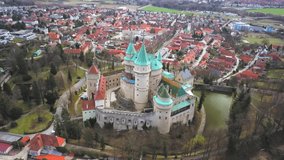 Aerial drone shot, View beautiful landscape on Bojnice castle in city, mountains background in summer sunny day with blue sky, Drone 4K Video
