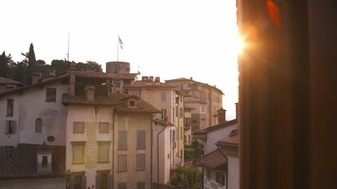 Early morning sunrise in Citta Alta ancient upper town of beautiful Bergamo city in alpine Lombardy region of northern Italy. Red tiled roofs and windows with wooden shutters of old buildings
