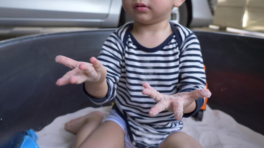 slow motion, cute child playing sand in playground of pre-kindergarten