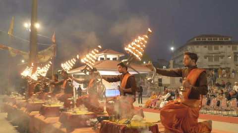 Pujaris or Brahmins (Hindu Priests) Performing Ganga Pooja in traditional cloths during sunrise at Varanasi ghat, India (March 2019)