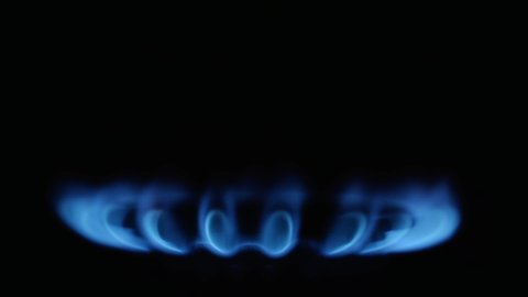 Kitchen burner turning on.Stove side burner igniting into a blue cooking flame. Natural gas inflammation, close up.