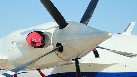 Closeup high detailed view of engine and airscrew of modern turboprop airplane standing on parking place at airport.