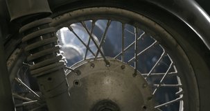 Shifting focus between two wheels with spokes on old vintage motorbikes in a dusty storage shed or workshop in a low angle close up view