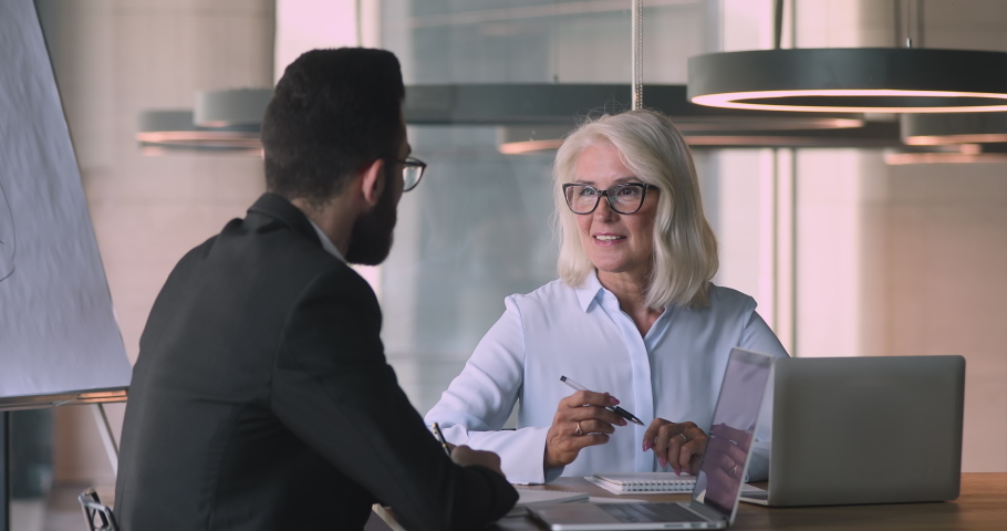 Happy middle aged mature caucasian businesswoman and young arabic arab businessman talking negotiating handshaking at office business meeting make commercial partnership agreement deal concept Royalty-Free Stock Footage #1036280456