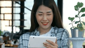 Video 4k of happy woman using digital tablet in a cafe