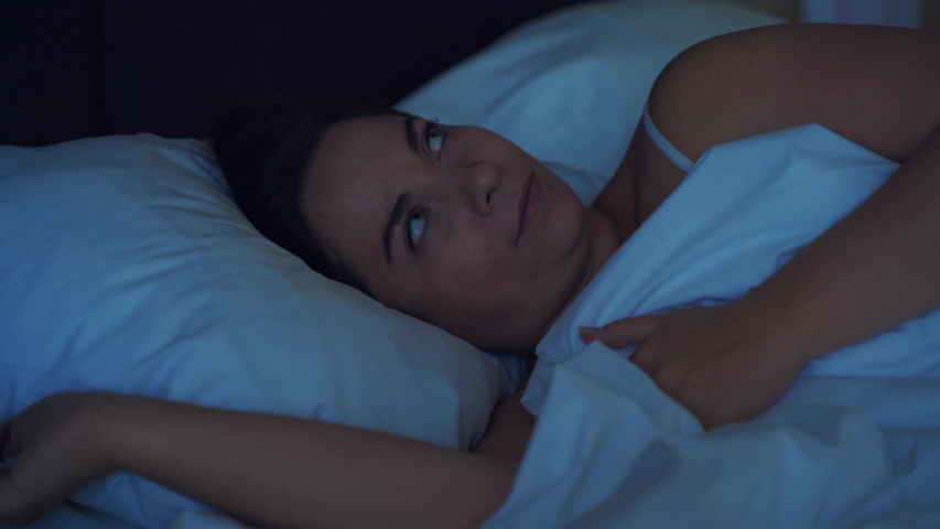 Young stressed woman cannot sleep due to noise of her neighbors from above, irritated and stressful covers her head and ears with pillow Royalty-Free Stock Footage #1036284224
