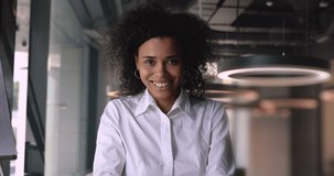 Smiling happy african american mixed race businesswoman talking consulting client online make conference call job interview look at camera record online training, video conference concept webcam view