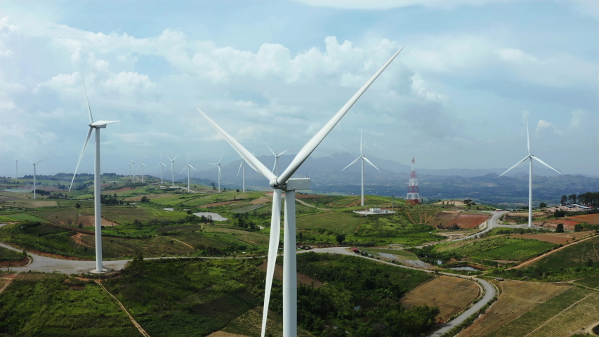 Aerial view of windmills with digitally generated holographic display tech data visualization. Wind power turbines generating clean renewable energy for sustainable development in a green ecologic way Royalty-Free Stock Footage #1036297358
