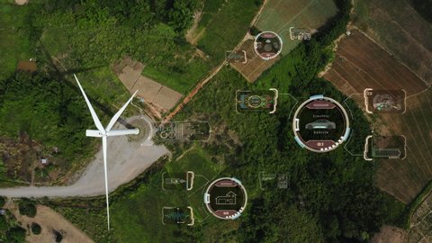 Aerial top view, windmills with digitally generated holographic display tech data visualization. Wind power turbines generating clean renewable energy for sustainable development in green ecologic way
