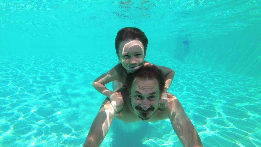 Father and son swimming underwater in swimming pool like a dolphin. Fun weekend in water park spending together. Family concept | Shutterstock HD Video #1036305077