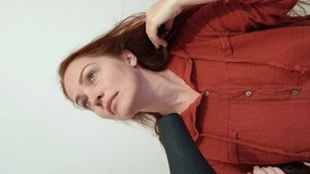 Woman drying hair using hair dryer, vertical video