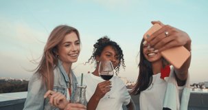 Group of young people having fun at a rooftop party, taking selfie. Focus on the people in the middle. 4k slow motion raw video footage 60 fps
