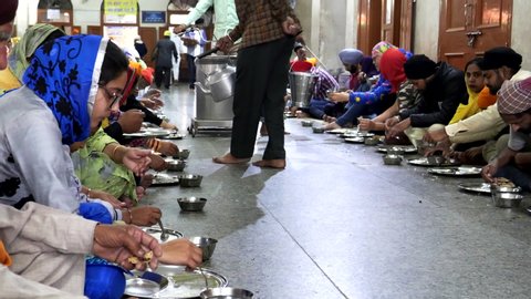 AMRITSAR, INDIA - MARCH 19, 2019: water being served at to patrons of golden temple's food hall in amritsar, india