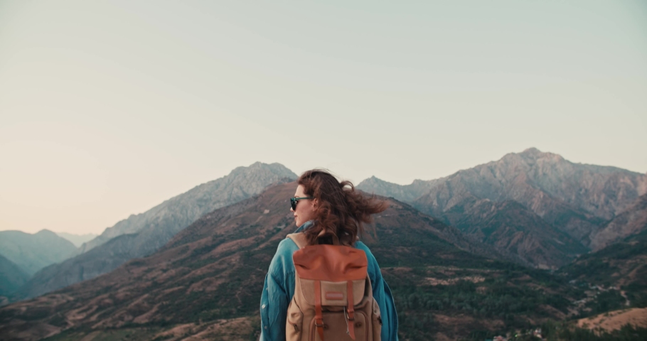Young caucasian girl going for an adventure, hiking in beautiful mountains, having an active vacation - zennism, freedom, recreational pursuit concept 4k footage