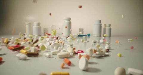 Closeup shot of different pills falling on table with tablets cans and syringes - mosern drug and pharmacy addiction, pharmaceutical industry concept 4k footage