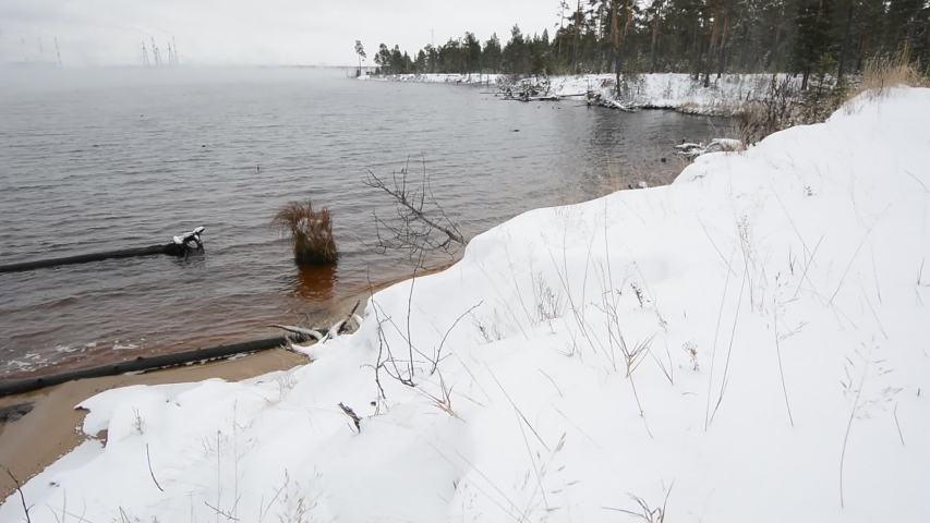 Beautiful winter river with snow on the banks of the forest.
