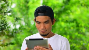 Man holding Mobile smartphone using smart phone to play game online fill happy so much green background ,Asian man Success achievement  looking on smart phone