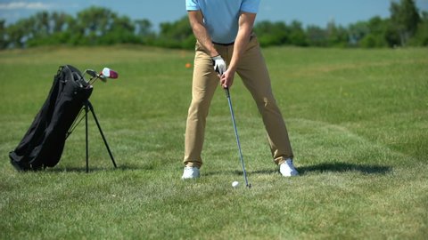 Inexperienced rich man hitting past golf ball displeased with failed shot, loser