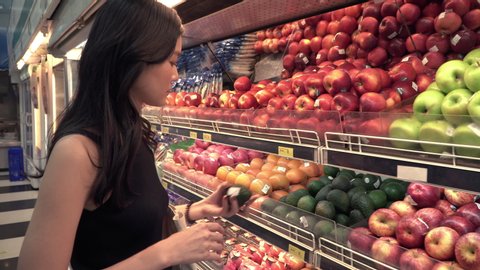 4K asian woman shopping fruit avocado and apple from shelf in super market